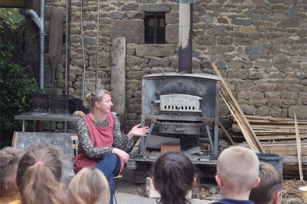 Photo de Camille contant devant le four à bois de la Ferme du Bas Val