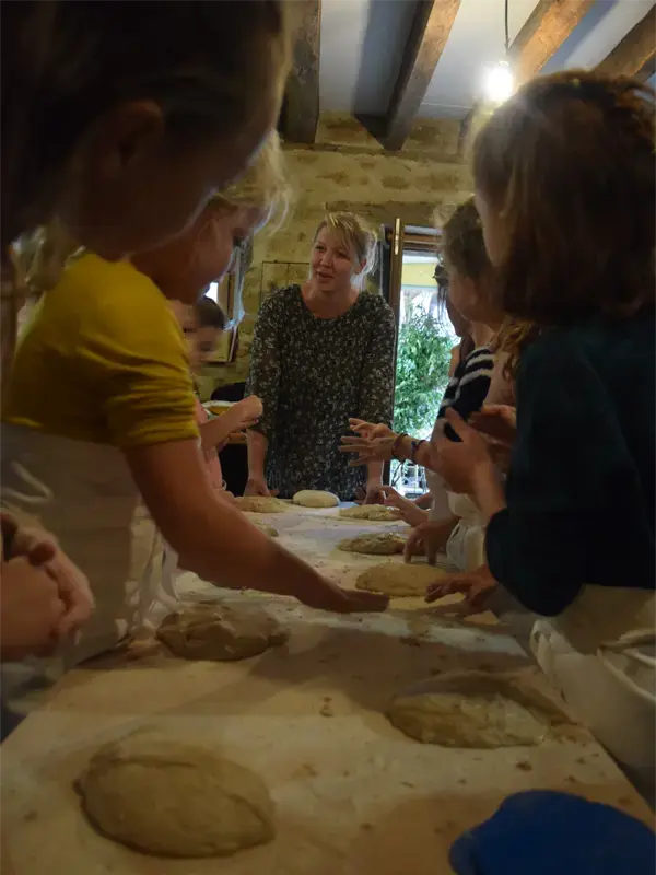 Image d'une animation avec les enfants pendant l'étape du façonnage du pain au Fournil Animé